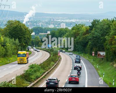 Mainz, Deutschland. 14. Aug. 2023. Vom Autobahnkreuz Mainz fahren Autos auf der A643 in Richtung Wiesbaden. Die Bundesregierung will die Autobahn A643 auf sechs Spuren ausdehnen. Die Erweiterung der A643 auf sechs Fahrspuren plus eine harte Schulter zwischen dem Autobahnkreuz Mainz und der Schiersteiner-Brücke wird in Mainz seit Jahren heftig umstritten, weil die Autobahn durch das Naturschutzgebiet Mainzer Sand verläuft, das in Europa einzigartig ist. Kredit: Andreas Arnold/dpa/Alamy Live News Stockfoto