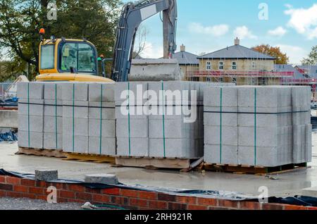 Betonblöcke werden an die Baustelle geliefert und neben dem Arbeitsplatz platziert und sind bereit für Mauerwerk Stockfoto