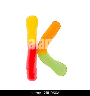 Buchstabe K aus mehrfarbigen Gummiwürmern und isoliert auf reinweißem Hintergrund. Konzept des Lebensmittelalphabets. Ein Buchstabe der süßen Essensschrift Easy Stockfoto
