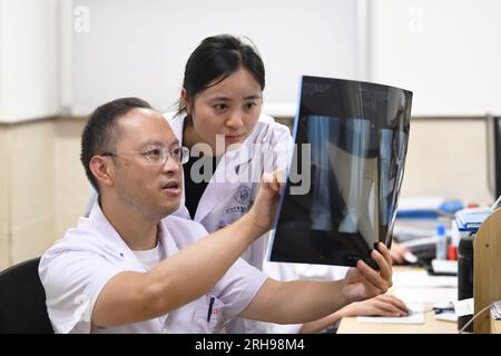 GUIYANG, CHINA - 15. AUGUST 2023 - Wang Lei (L), Direktor der Abteilung für Knochenchirurgie des Volkskrankenhauses, arbeitet an einer klinischen Diagnose Stockfoto