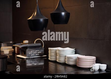 Stapelbare Teller auf der Theke in der modernen Küche des Restaurants Stockfoto