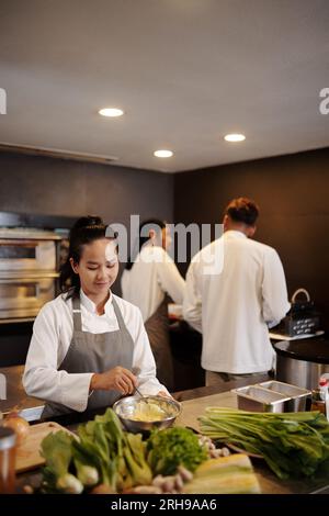 Ein Team von Köchen, die in der Küche eines modernen Restaurants arbeiten Stockfoto