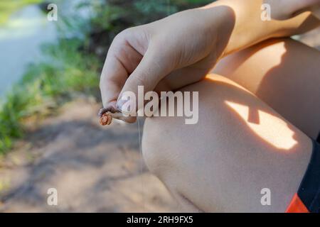 Ein Teenager richtet einen Köder ein, um Fische zu fangen. Sportfischen auf dem Fluss im Sommer. Stockfoto