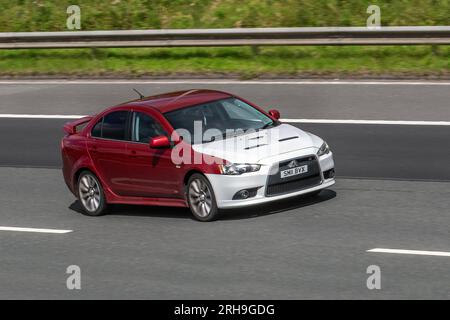 2011 Rot Weiß zweifarbig Mitsubishi Lancer GS4; Limousine 1798 ccm; Fahrt mit hoher Geschwindigkeit auf der Autobahn M6 im Großraum Manchester, Großbritannien Stockfoto