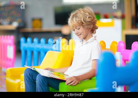 Kleiner Junge im Kindergarten oder in der Kinderbetreuung. Kinder, die im Vorschulalter mit bunten pädagogischen Spielzeugen spielen. Kinder spielen auf dem Hallenspielplatz. Stockfoto