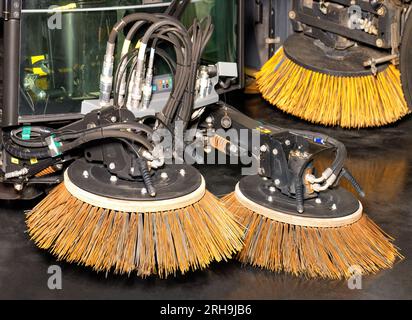 Zwei unabhängig voneinander gesteuerte hydraulisch einstellbare Frontbürsten als Anhängekupplung für die Reinigung von Straßen in der Stadt. Stockfoto