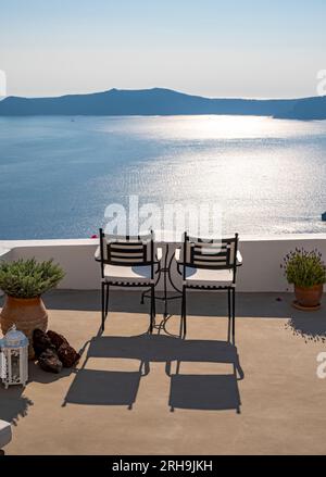 Terrasse mit Stühlen, Blick auf Meer und Caldera, Fira, Santorin, Griechenland Stockfoto