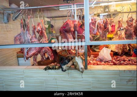 Ziegenfleisch hängt an einem Metzger, Händler auf dem Kuala Lumpur Straßenmarkt, die Fleisch an Leute verkaufen Stockfoto