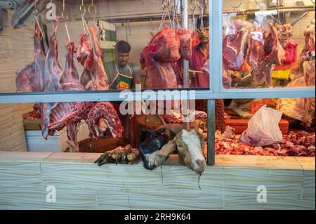 Ziegenfleisch hängt an einem Metzger, Händler auf dem Kuala Lumpur Straßenmarkt, die Fleisch an Leute verkaufen Stockfoto