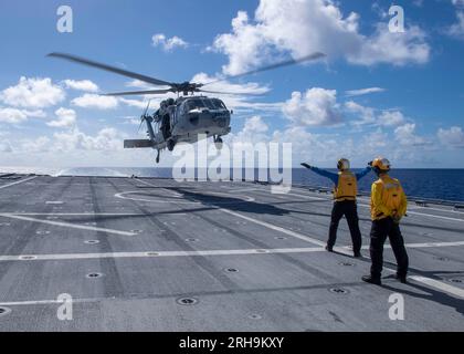 Die Seeleute signalisieren am 20. Juli 2023 einen MH-60S Sea Hawk Hubschrauber im Pazifik. Foto von Christopher Thomas Stockfoto