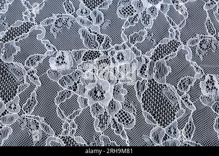 Stoffstruktur. Netzstruktur. Stoffstruktur mit Blumen. Schnurstruktur, Netzgewebe. Schwarzer Synthetikstoff. Kann als Hintergrund verwendet werden Stockfoto