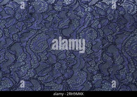 Stoffstruktur. Netzstruktur. Stoffstruktur mit Blumen. Schnurstruktur, Netzgewebe. Schwarzer Synthetikstoff. Kann als Hintergrund verwendet werden Stockfoto