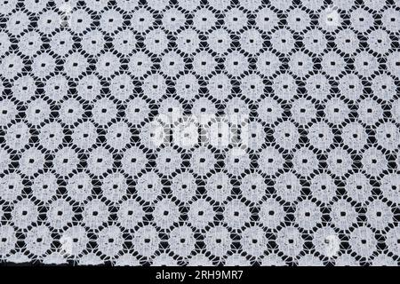 Stoffstruktur. Netzstruktur. Stoffstruktur mit Blumen. Schnurstruktur, Netzgewebe. Schwarzer Synthetikstoff. Kann als Hintergrund verwendet werden Stockfoto
