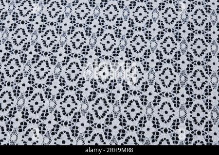 Stoffstruktur. Netzstruktur. Stoffstruktur mit Blumen. Schnurstruktur, Netzgewebe. Schwarzer Synthetikstoff. Kann als Hintergrund verwendet werden Stockfoto