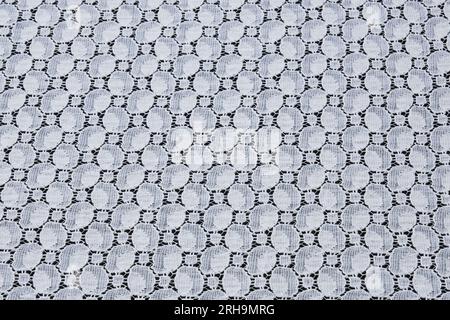Stoffstruktur. Netzstruktur. Stoffstruktur mit Blumen. Schnurstruktur, Netzgewebe. Schwarzer Synthetikstoff. Kann als Hintergrund verwendet werden Stockfoto