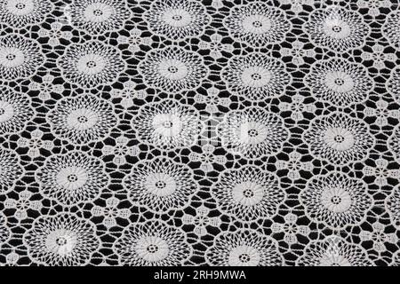 Stoffstruktur. Netzstruktur. Stoffstruktur mit Blumen. Schnurstruktur, Netzgewebe. Schwarzer Synthetikstoff. Kann als Hintergrund verwendet werden Stockfoto