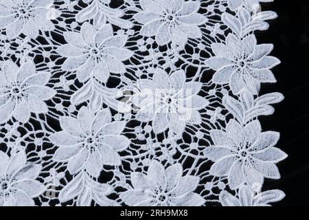 Stoffstruktur. Netzstruktur. Stoffstruktur mit Blumen. Schnurstruktur, Netzgewebe. Schwarzer Synthetikstoff. Kann als Hintergrund verwendet werden Stockfoto
