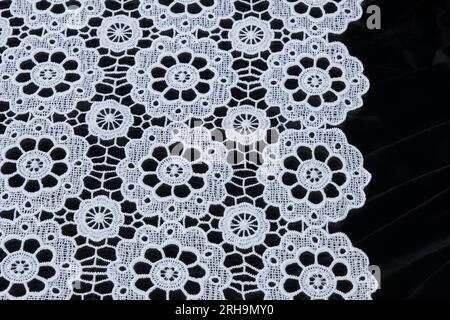 Stoffstruktur. Netzstruktur. Stoffstruktur mit Blumen. Schnurstruktur, Netzgewebe. Schwarzer Synthetikstoff. Kann als Hintergrund verwendet werden Stockfoto