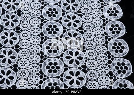 Stoffstruktur. Netzstruktur. Stoffstruktur mit Blumen. Schnurstruktur, Netzgewebe. Schwarzer Synthetikstoff. Kann als Hintergrund verwendet werden Stockfoto