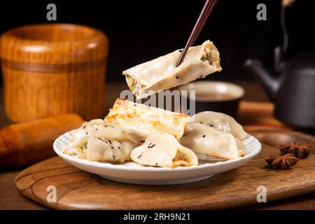 Gebratene Knödel Gyoza auf einem Teller auf einem grauen Betongrund, Draufsicht Stockfoto