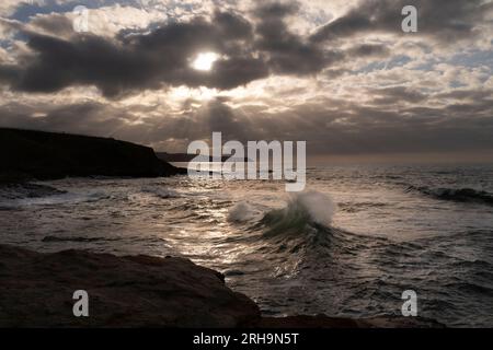 Blick auf einen Sonnenuntergang mit der Sonne durch die Wolken über dem Kantabrischen Meer. Goldene Stunde. Stockfoto