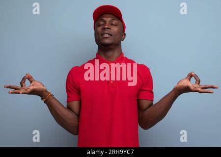 Ein junger Amerikaner in Baseballmütze und T-Shirt-Uniform arbeitet für ein Lebensmittelunternehmen Stockfoto