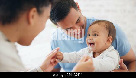 Baby, spielt und Vater mit mutter im Schlafzimmer, glücklich mit Liebe oder Fürsorge am Wochenende. Fröhlich, kindlich und verspielt mit Eltern oder Vater, um sich zu verbinden Stockfoto