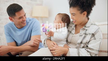 Zeit für Paare, Familie und eine schöne Zeit mit Baby, mutter und Vater, die aus Spaß mit Spielzeug spielen, zusammen zu Hause, im Schlafzimmer oder im Kinderzimmer lachen. Neugeborene, Kleinkinder und Stockfoto