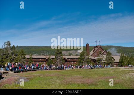 Touristen, die auf den Ausbruch von Old Faithful warten, Old Faithful Inn im Upper Geyser Basin, Yellowstone-Nationalpark, Wyoming, Vereinigte Staaten von Amerika Stockfoto