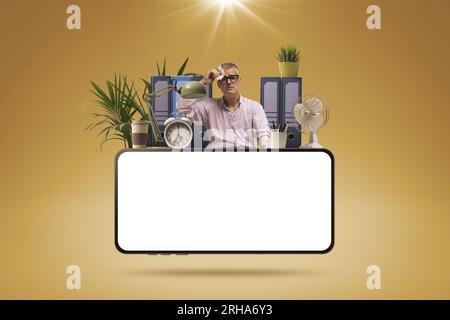 Gestresster Geschäftsmann, der unter Hitze und blanken Smartphones, Hitzewellen und heißen Temperaturen leidet Stockfoto