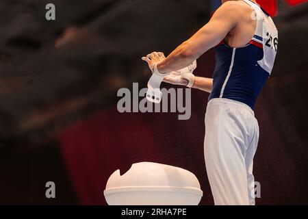 Gymnast trage Kreide in den Händen von Magnesia-Ständen auf, Vorbereitung für das Training auf unebenen Stangen Stockfoto