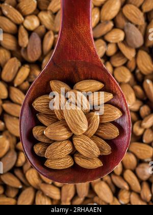 Getrocknete Mandeln. Mandelkerne liegen in einem Holzlöffel. Draufsicht der Muttern (Nahaufnahme). Werbefotografie für Marketplace-Sites oder Online-Shops. Stockfoto