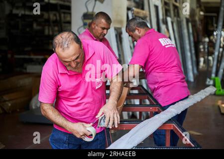 Arbeiter, die Kartonkartons für den Versand im Lager verpacken. Ein Bediener schließt einen Karton mit Klebeband in einem Lager. Stockfoto