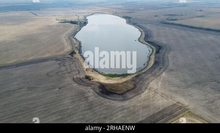 Remote Saskatchewan: Luftdrohnenaufnahme von ruhigem Wasser in arider brauner Landschaft. Der Kontrast der Natur in einer abgeschiedenen ländlichen Umgebung Stockfoto