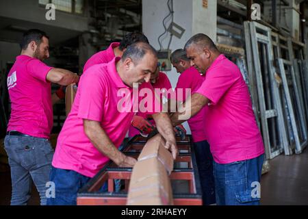 Arbeiter, die Kartonkartons für den Versand im Lager verpacken. Ein Bediener schließt einen Karton mit Klebeband in einem Lager. Stockfoto