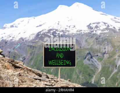 Symbol für Inklusion und Wohlbefinden. Konzeptbegriffe Inklusion und Wohlbefinden auf wunderschöner Kreidetafel. Schöner Elbusberg im Hintergrund. Motivationa Stockfoto