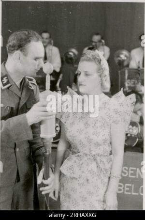 SS-Fotograf, Homann (1943) viele Fotos von Rheinhardt Heydrichs Beerdigung; KB-Betrieb - Schienenbeladung, Ausrüstung, Aufnahmestudio, musikalische Darbietungen; Porträtfotos einzelner Soldaten, leitende Offiziere; medizinisches Personal; Infanterie mit Rudelpferden in bergigem Gelände; Soldaten klettern; Himmler beobachten Soldatenausbildung; Soldat mit Hund; Weihnachtsfeier; Winterkampfpositionen; Militärfriedhof. Stockfoto