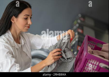 Junge brünette Frau, die Wäsche macht. Stockfoto