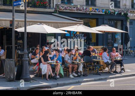 Paris, FR - 31. August 2022: Gäste essen auf der Terrasse des Restaurants Cafe Livres Stockfoto