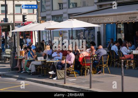 Paris, FR - 31. August 2022: Gäste essen auf der Terrasse des Restaurants Cafe Livres Stockfoto