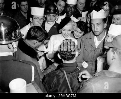 Korea: Februar 1954. Marilyn Monroe besucht die Truppen in Korea und unterhält über 100.000 Soldaten an 10 verschiedenen Orten. Hier signiert sie ein Autogramm für einen glücklichen Soldaten. Stockfoto