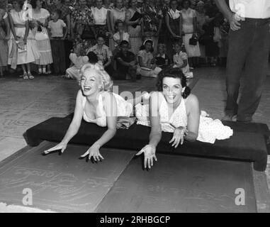 Hollywood, Kalifornien: Am 26. Juni 1953 legten die Schauspielerinnen Marilyn Monroe {L) und Jane Russell ihre Handabdrücke in Nasszement im Grauman's Chinese Theater ab, um ihren neuesten Film „Gentlemen prefer Blondes“ zu bewerben. Stockfoto