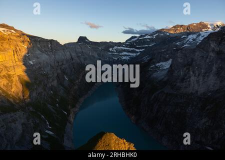 Epischer Sonnenuntergang über einem alpinen See namens Limmerensee in der Schweiz. Wundervolle Landschaft in den alpen. Die Sonne scheint zu den Gipfeln der Berge. Stockfoto