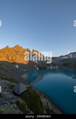 Ein wunderbarer Blick auf den Horizont bei einem wunderschönen Sonnenuntergang in den alpen der Schweiz an einem alpinen See namens Schottensee. Stockfoto