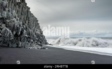 Wellen stürzen am schwarzen Sandstrand von Reynisfjara, Vik, Süd-Island, Island Stockfoto