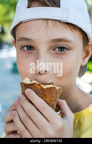 Porträt eines Jungen mit Schokolade auf der Nase, der einen Eiscreme-Tdelnik isst Stockfoto