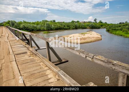 Alte Holzbrücke über den Fluss Sluch. Dorf Liukhcha in der Region Rivne, Ukraine. Stockfoto