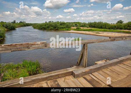 Alte Holzbrücke über den Fluss Sluch. Dorf Liukhcha in der Region Rivne, Ukraine. Stockfoto