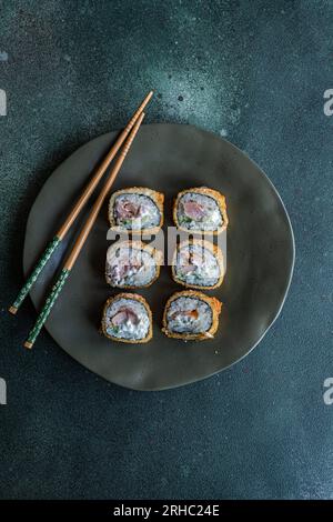 Draufsicht auf einen Teller mit gebratenen Thunfisch-Maki-Brötchen auf einem Teller Stockfoto