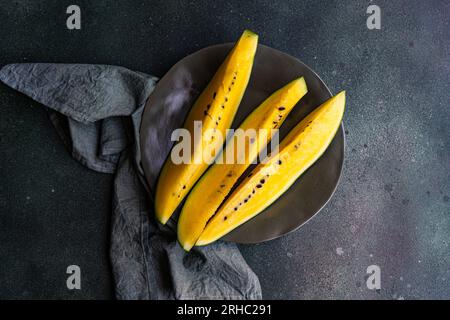 Draufsicht von drei Scheiben gelber Wassermelone auf einem Teller Stockfoto